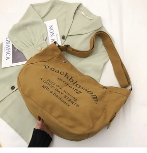 Détail du sac fourre-tout en toile jaune moutarde avec imprimé artistique et bandoulière