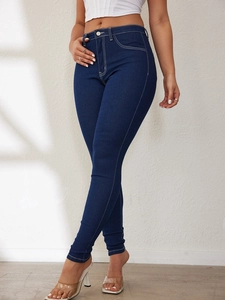Detail shot of dark blue skinny jeans featuring white contrast stitching and high waist fit