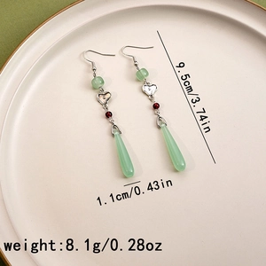 Detailed view of green drop earrings on ceramic tray with size and weight dimensions