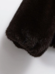 Close-up of the plush faux fur texture on a dark brown bomber jacket for women