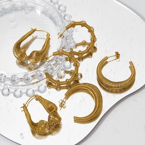 Textured gold twisted C-shape hoop earrings with intricate metallic wire wrap design
