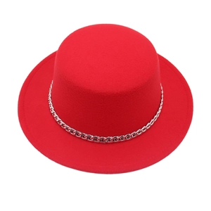 Detail of red wool felt boater hat with decorative silver metal chain on white background