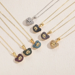 Détail de pendentifs ours avec zircons multicolores sertis sur des chaînes plaquées or 14K