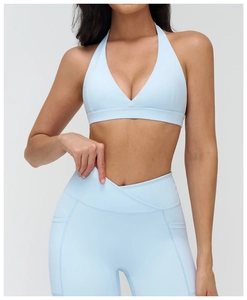 Dettaglio dei leggings yoga con vita a V incrociata e reggiseno sportivo celeste