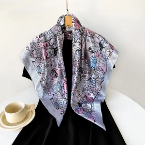 Detail of 90cm square satin silk scarf with colorful cartoon cat print on a wooden hanger