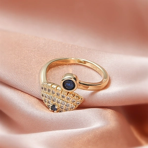 Macro shot of gold-plated evil eye ring featuring blue sapphire gems and pave diamonds