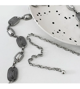 Detail view of retro silver metal waist chain with engraved links and adjustable ball charm