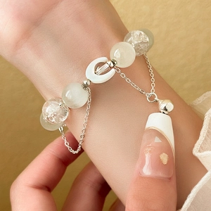 Detailed macro view of beaded moon bracelet with light green and white glass crystal beads