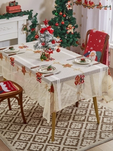 Close-up of beige Christmas tablecloth with red embroidery and festive chair covers