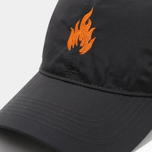 Close-up of orange flame embroidery on black breathable mesh baseball cap fabric