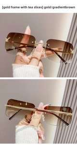 Close-up of rimless square sunglasses with rhinestone butterfly and gradient brown lenses