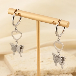 Silver butterfly and hollow heart earrings displayed on a gold T-stand holder