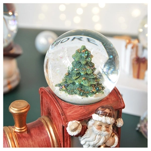Detail of red vintage train snow globe with Christmas tree and festive MORE lettering