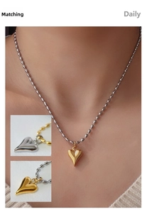Détail de la chaîne à billes en acier plaqué or 18k avec pendentifs cœurs bicolores