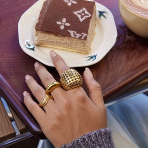 Détail de l'ensemble de trois bagues dorées avec café et dessert sur un plateau en bois