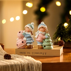 Close-up of ceramic Christmas boy and girl figurines with warm glowing night lights