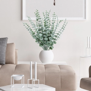 Artificial eucalyptus stems in white ceramic vase for minimalist home decor