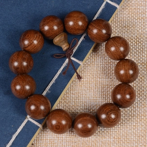 Macro shot of sandalwood prayer beads showing natural wood grain on a vintage book