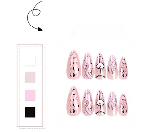 Detail of pink almond false nails with black leopard spots, eye art, and crystal accents
