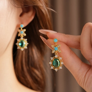 Détails de boucles d'oreilles vintage dorées avec zircon vert ovale et fleurs