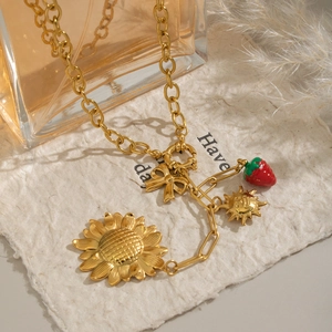 Pastoral sunflower and strawberry gold necklace with butterfly charms on texture paper