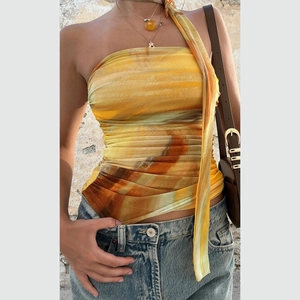 Détail d'un haut bustier floral avec écharpe assortie et imprimé tie-dye abstrait