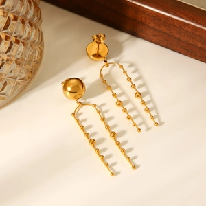Detail of gold bead earrings featuring double-row beaded chain tassel in stainless steel