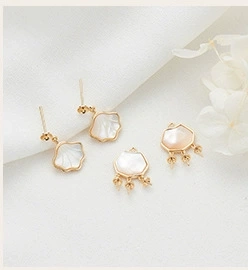 Detailed close-up of 14K gold-plated shell-shaped earrings and necklace with pearl luster