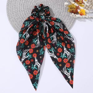 Chouchou d'Halloween avec longs rubans, imprimé main de squelette et fleurs sur fond blanc