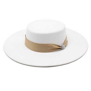 Close-up of white felt boater hat with champagne ribbon and rhinestone buckle detail