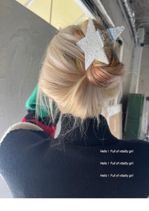 Detailed view of a silver glitter star hair claw clip worn on a woman's bun hairstyle