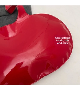 Detailed close-up of the glossy red patent leather surface with precise stitching on the bag