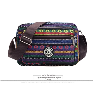 Detail of multi-color striped ethnic canvas bag featuring a front zipper and logo