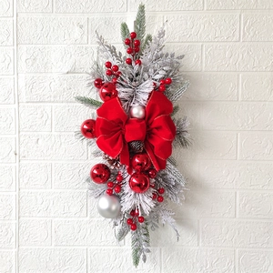 Detail of Christmas teardrop swag with red velvet bow, berries, and white ornaments