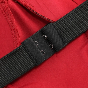 Detailaufnahme des roten Kleides mit schwarzem Gummiband und Metallhaken-Verschluss