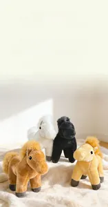 Détail de porte-clés poney en peluche en quatre couleurs sur un tapis blanc doux