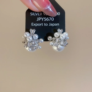 Detailed view of S925 silver pearl earrings with sparkling zircon floral clusters
