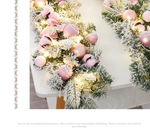 Détail de guirlande de Noël givrée avec boules roses et guirlandes LED chaudes