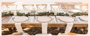 Outdoor wedding table setting featuring cream woven placemats and elegant tableware