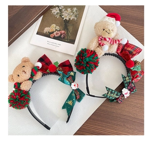 Detail of Christmas headband with plush bear, plaid bow and festive red green ornaments