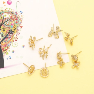 Detailed view of assorted gold animal earrings with zircons and pearls on a card