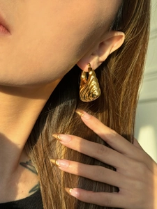 Detail of vintage 18k gold plated croissant earring with hollow rippled texture