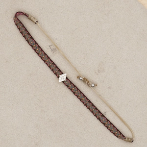 Detailed view of woven tribal bracelet with rhinestone diamond center and adjustable knot