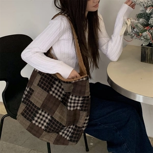 Detail of checkered tote bag featuring brown faux shearling trim and plush lining texture