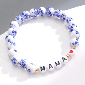 Dettaglio del bracciale in perline di ceramica con motivi floreali blu e lettere MAMA
