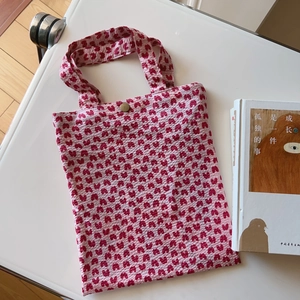 Detailed view of pink floral cotton tote bag with bronze buckle and textured fabric