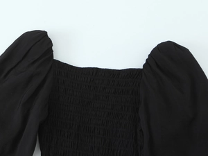 Détail de l'encolure carrée avec buste froncé élastique et manches bouffantes noires