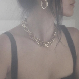 Close-up of a 18k gold-plated chunky link chain necklace worn by a fashion model