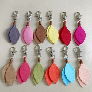 Flat lay of colorful suede leaf-shaped keychains in various vibrant pastel shades