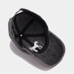 Macro detail of horse embroidery and metal buckle on dark gray washed baseball cap